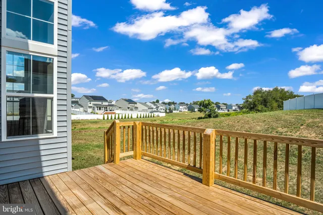 a view of a balcony with wooden floor & fence