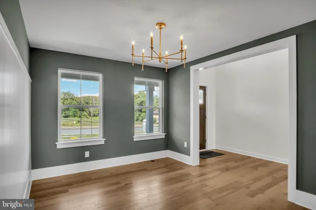 an empty room with windows and chandelier