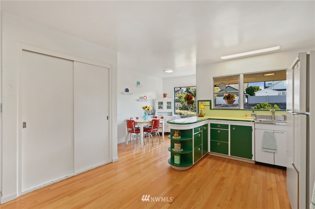 831 Rucker Avenue Everett, WA 98201 - Photo 13 of 40 a kitchen with a sink dishwasher a stove and a dining table with wooden floor