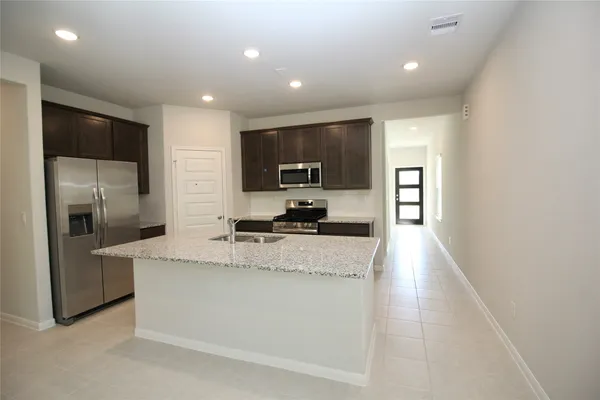 a kitchen with stainless steel appliances granite countertop a sink stove and refrigerator