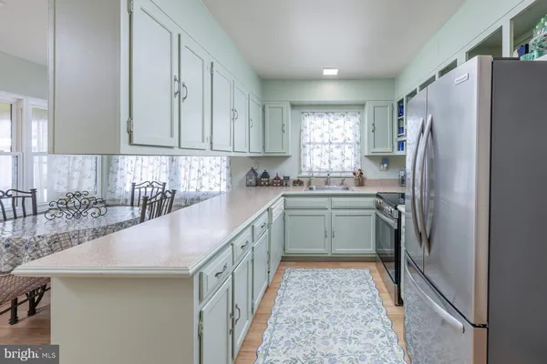 a kitchen with a sink a counter top space stainless steel appliances and cabinets