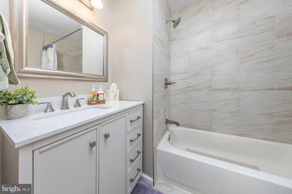 a bathroom with a sink a vanity and a bathtub