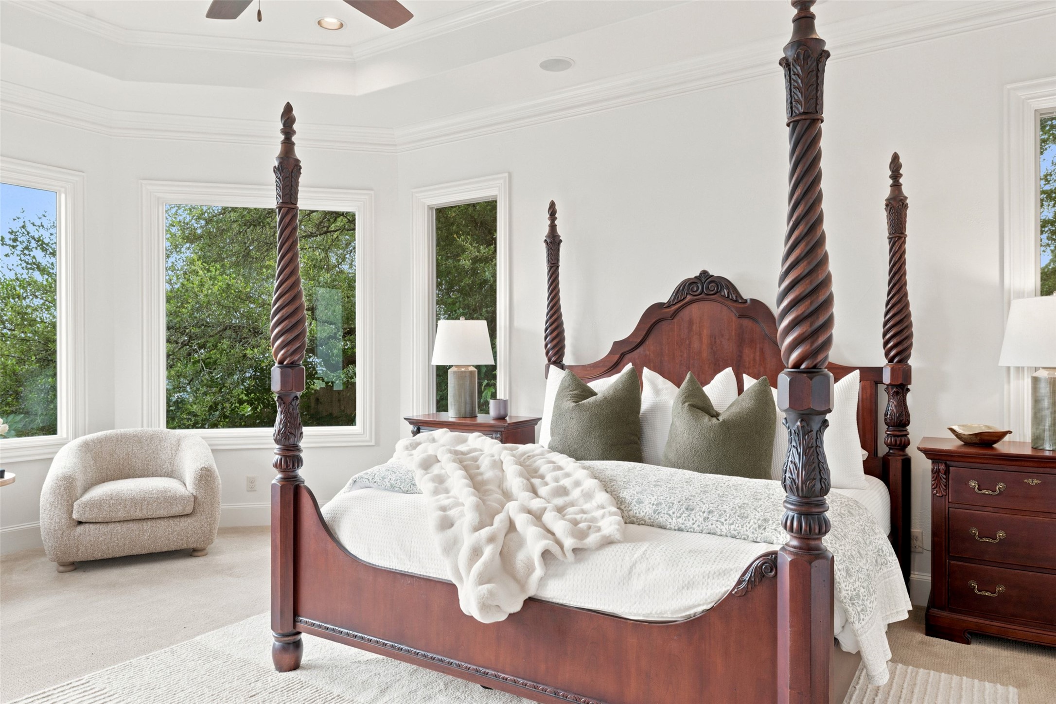 1414 The High Road Austin, TX 78746 - Photo 17 of 40 An inviting primary bedroom featuring a grand four-poster bed and bright windows with scenic outdoor views.
