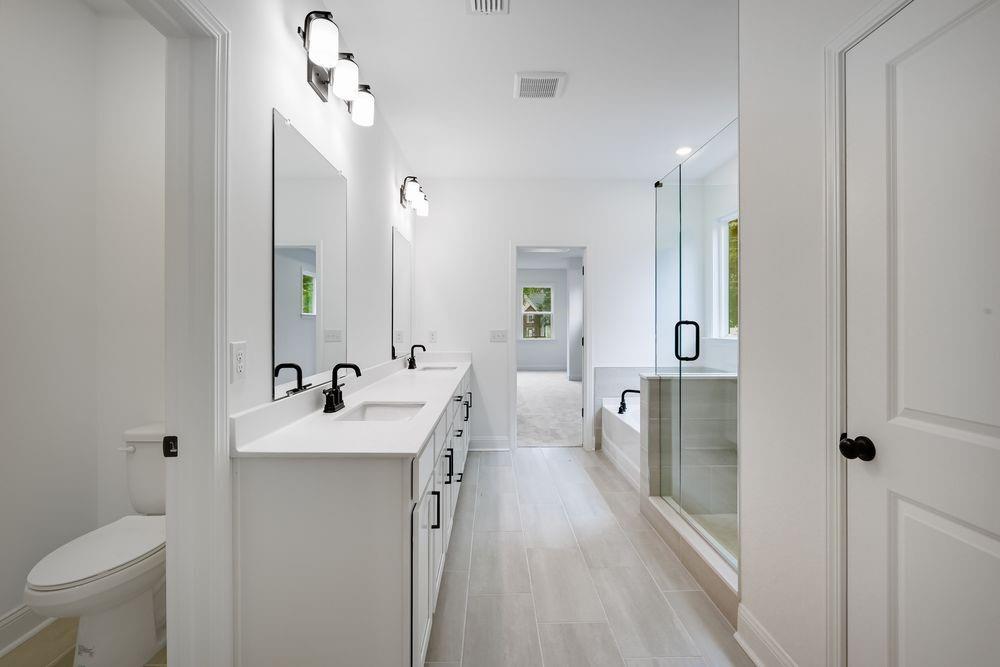 2311 Ellie Way Kennesaw, GA 30152 - Photo 14 of 35 a spacious bathroom with a toilet sink and mirror