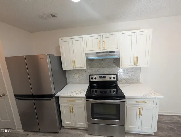 a white refrigerator freezer and a stove sitting inside of a kitchen