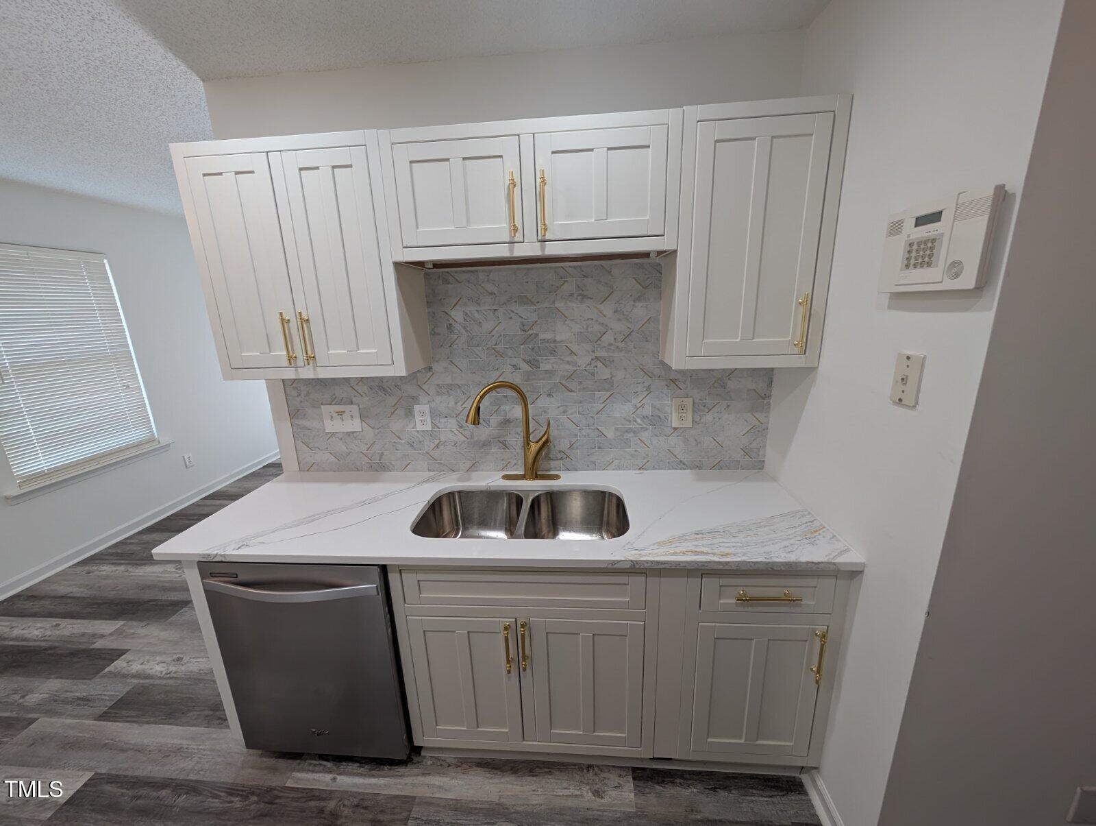 7528 Argent Valley Drive Raleigh, NC 27616 - Photo 13 of 47 a kitchen with white cabinets a sink and dishwasher