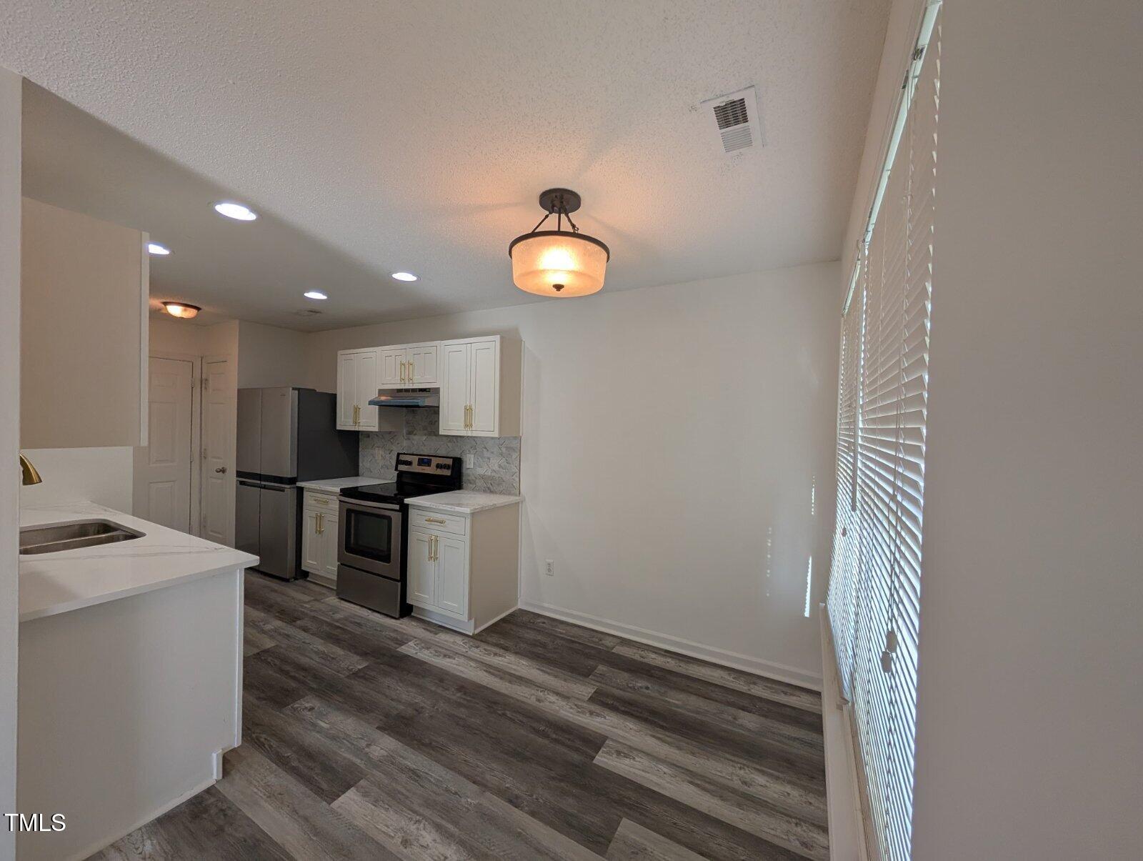7528 Argent Valley Drive Raleigh, NC 27616 - Photo 14 of 47 a kitchen with a refrigerator and a stove top oven