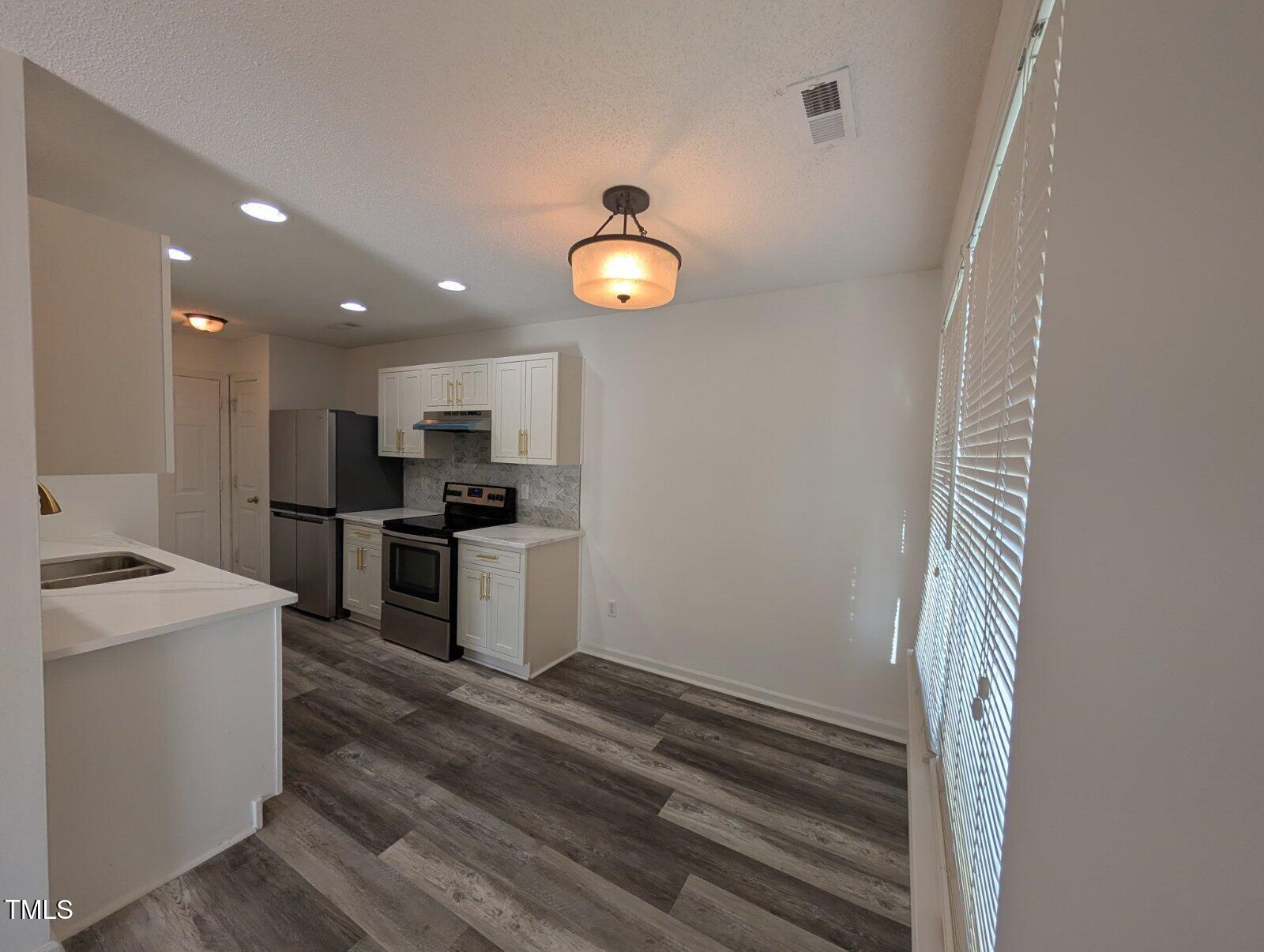 7528 Argent Valley Drive Raleigh, NC 27616 - Photo 16 of 47 a kitchen with a sink stainless steel appliances and cabinets