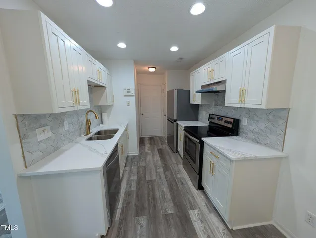 a kitchen with a sink stove top oven and refrigerator