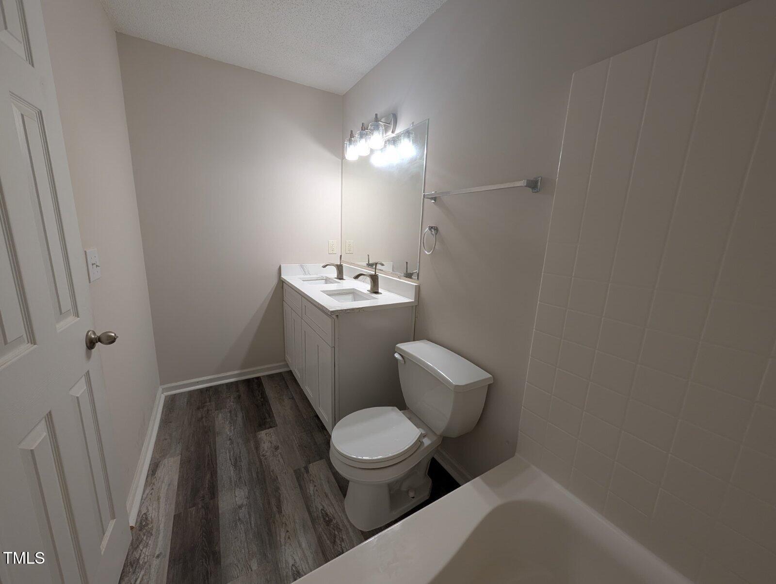 7528 Argent Valley Drive Raleigh, NC 27616 - Photo 23 of 47 a bathroom with a toilet a sink and wooden floor