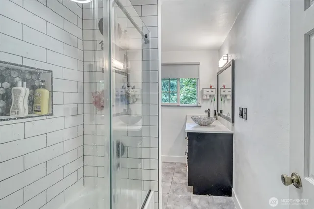 a bathroom with a granite countertop sink a toilet a mirror and shower