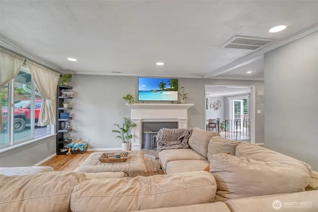 a bedroom with a bed a potted plant on dresser and a window
