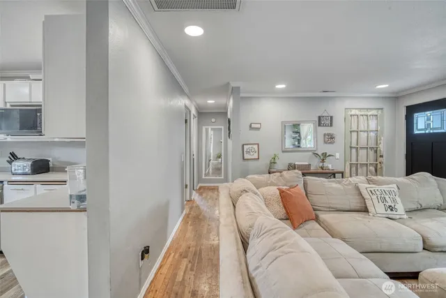 a living room with furniture white walls and a refrigerator