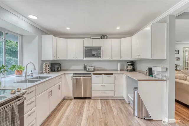 a kitchen with cabinets appliances a sink and a counter top space