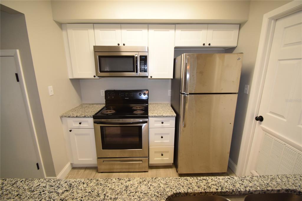 945 Castle Way, Unit 945 Lakeland, FL 33803 - Photo 4 of 16 a kitchen with a refrigerator stove and white cabinets