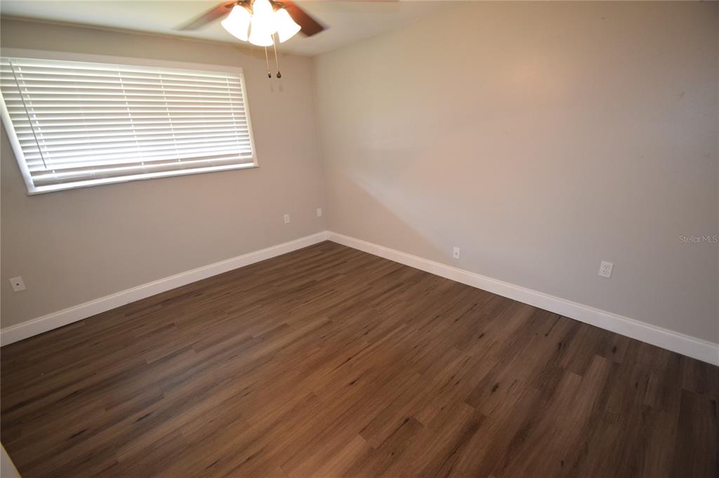 945 Castle Way, Unit 945 Lakeland, FL 33803 - Photo 7 of 16 a view of an empty room with wooden floor and a window