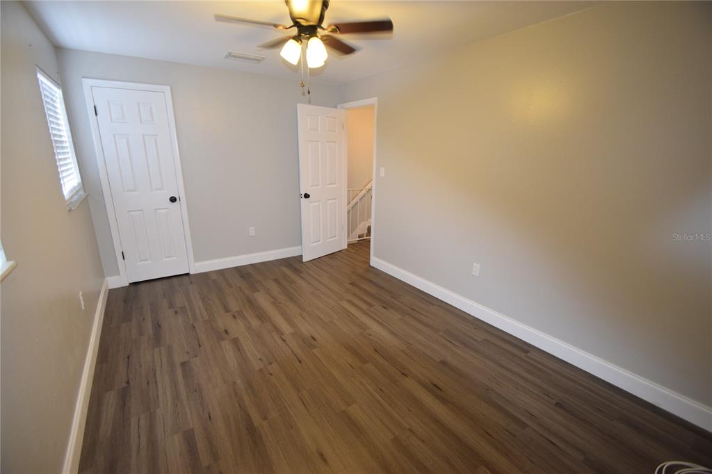 945 Castle Way, Unit 945 Lakeland, FL 33803 - Photo 8 of 16 an empty room with wooden floor fan and windows