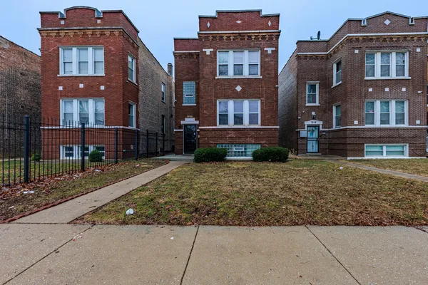 a front view of a residential apartment building with a yard