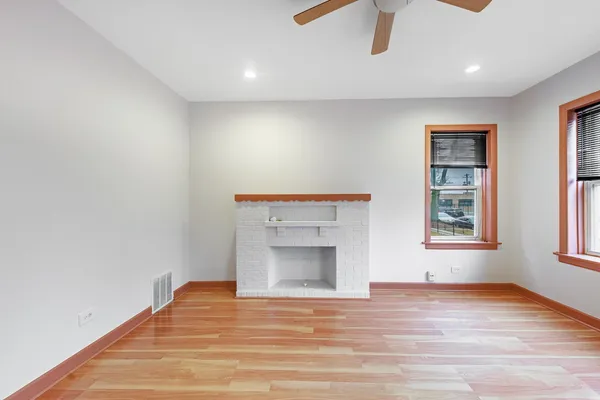 a view of an empty room with a window and fireplace
