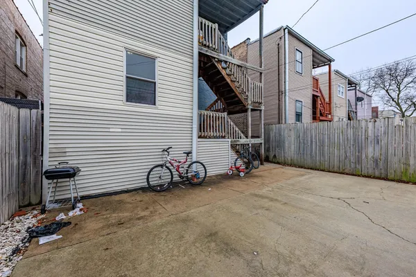 a view of a house with a small yard and a car parked beside it