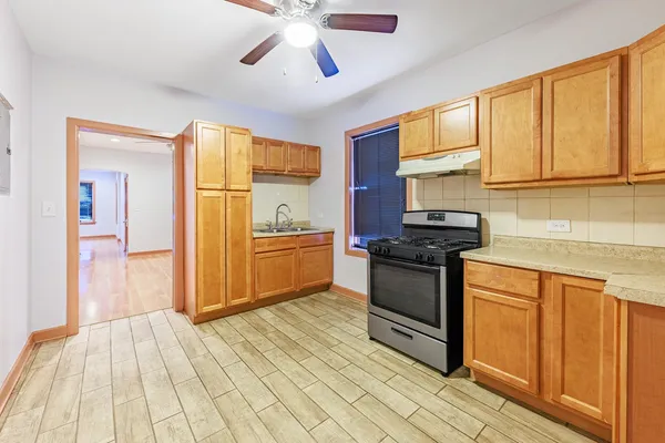 a kitchen with stainless steel appliances granite countertop a stove a sink and a refrigerator