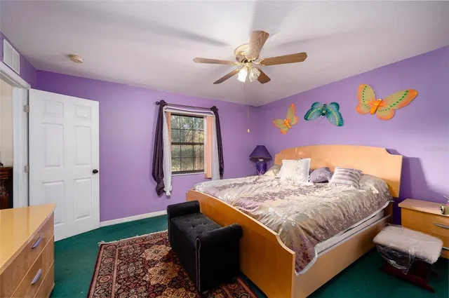 a bedroom with a bed a dresser and potted plant