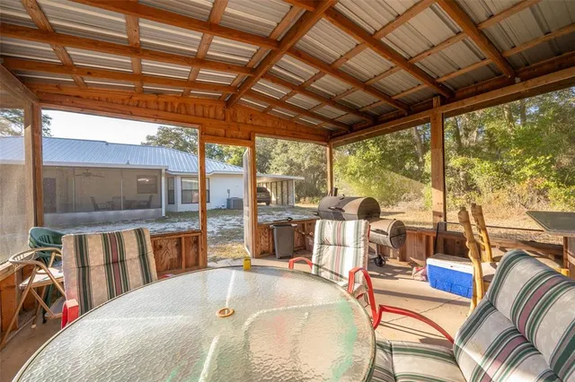 a view of a patio with table and chairs potted plants with wooden floor and fence