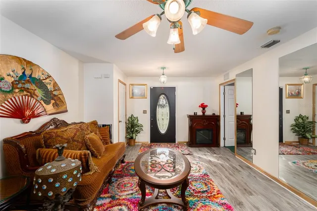 a living room with furniture a chandelier and a rug