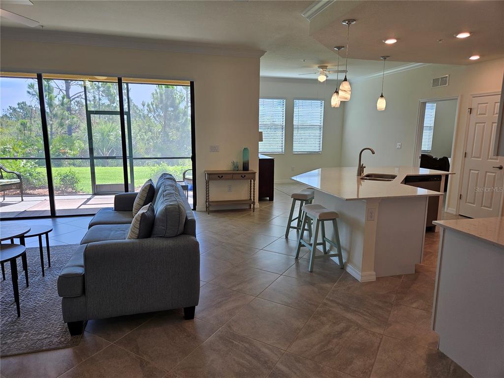 10039 Crooked Creek Drive, Unit 102 Venice, FL 34293 - Photo 12 of 36 a living room with furniture and a large window