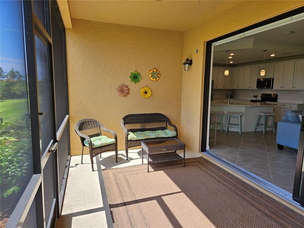 10039 Crooked Creek Drive, Unit 102 Venice, FL 34293 - Photo 22 of 36 a living room with a couch and a potted plant with wooden floor