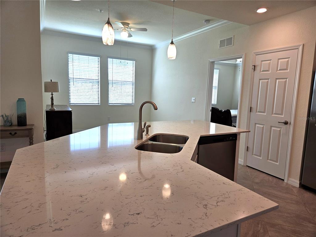 10039 Crooked Creek Drive, Unit 102 Venice, FL 34293 - Photo 24 of 36 a large white kitchen with a large island