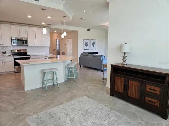 a bed sitting in a bedroom next to a window and a chandelier