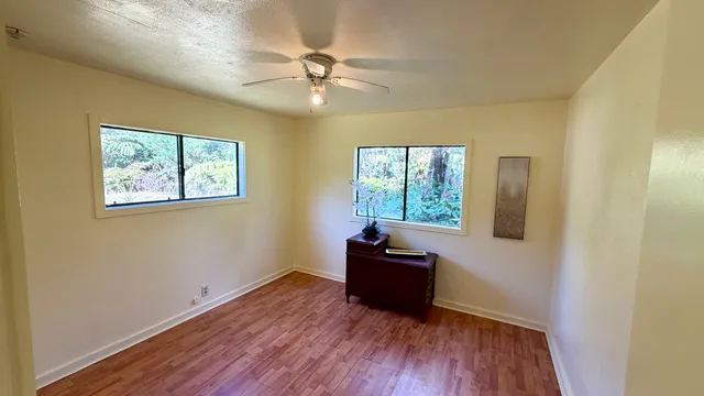 a view of a livingroom with wooden floor and a ceiling fan