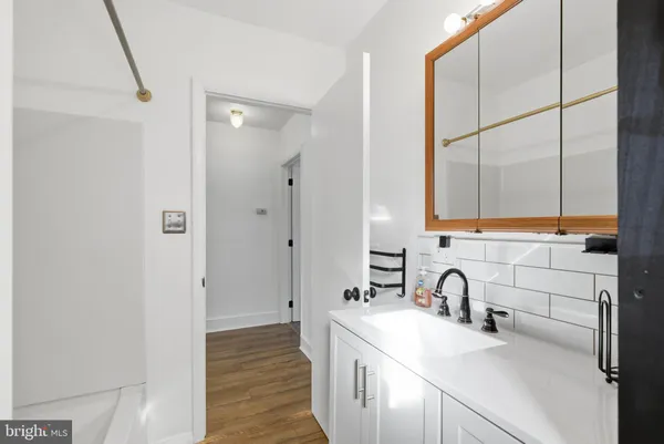 a bathroom with a tub shower sink and mirror