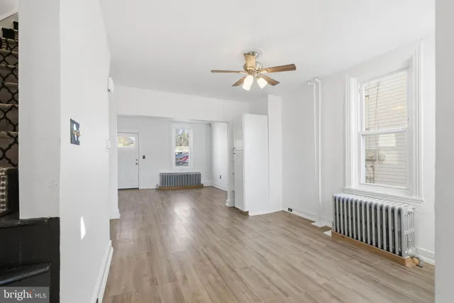 a view of a room with wooden floor and ceiling fan
