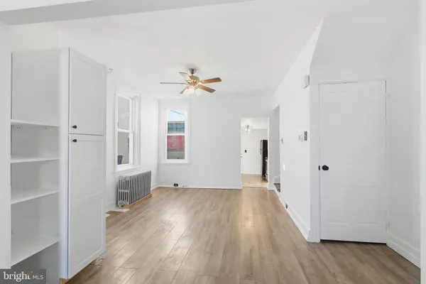 a view of a hallway with wooden floor and staircase