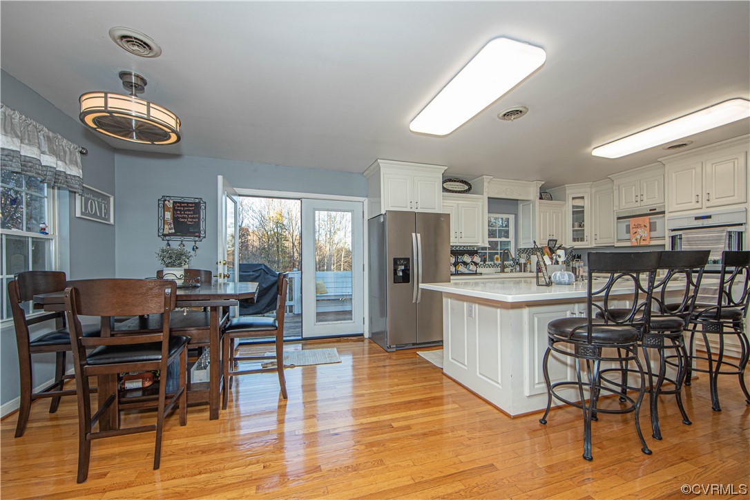 2330 Mosby Road Powhatan, VA 23139 - Photo 3 of 42 The kitchen has wood floors and corian countertops. The large island offer a spacious bar top for entertaining or move over to the breakfast nook and enjoy the view. French door lead you out to the spacious deck.