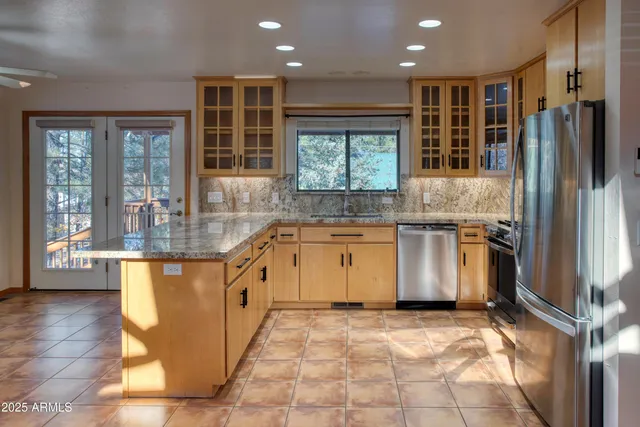 a kitchen with kitchen island granite countertop stainless steel appliances a stove sink and microwave