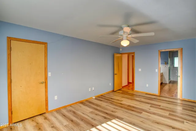 a view of a livingroom with a chandelier fan and a window
