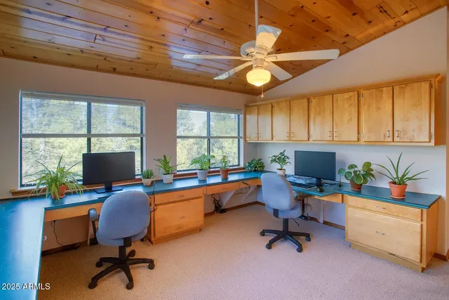 a view of a workspace with furniture and a window