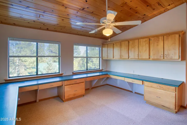 an empty room with a window and ceiling fan