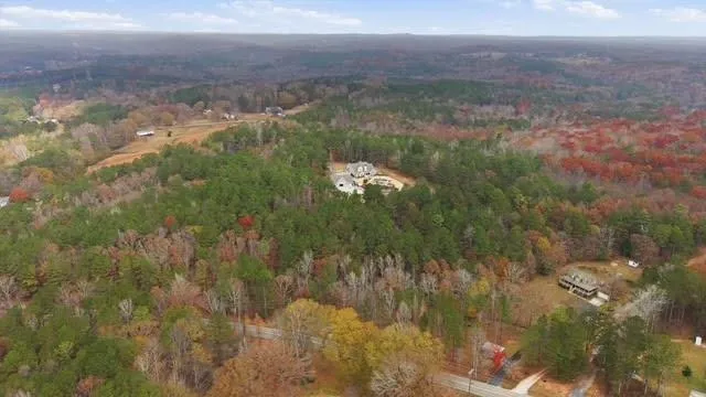 a bedroom with a bed painting on wall and a large window