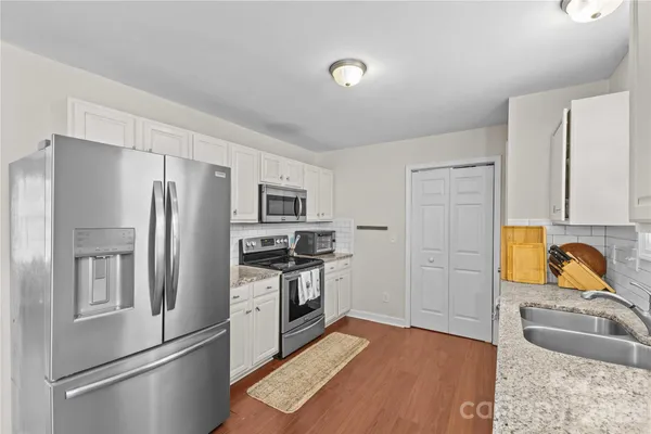 a kitchen with stainless steel appliances granite countertop a refrigerator stove and sink