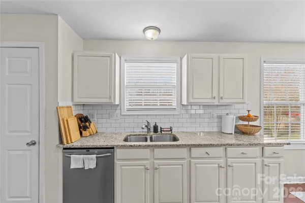 a kitchen with stainless steel appliances granite countertop a sink a stove and cabinets