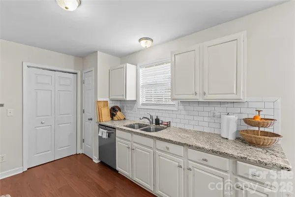 a kitchen with granite countertop white cabinets and white appliances
