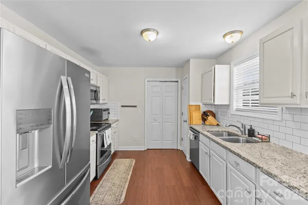 a kitchen with stainless steel appliances granite countertop a refrigerator and a sink