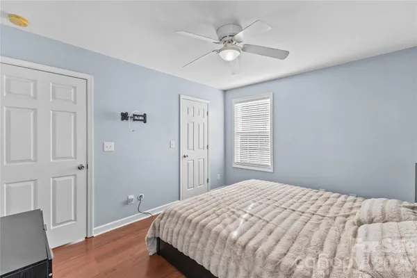 a bedroom with a large bed and a chandelier