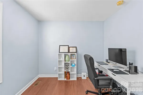 a view of a workspace with furniture and wooden floor