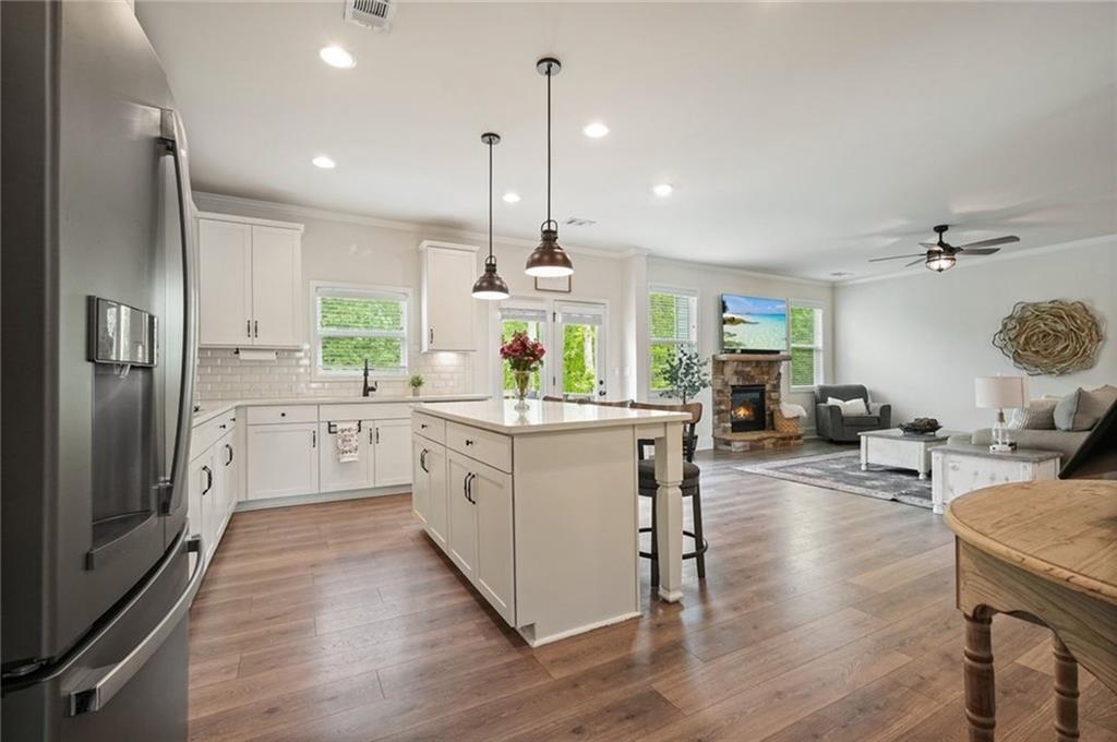 6915 Rambling Vale Dawsonville, GA 30534 - Photo 15 of 63 a kitchen with stainless steel appliances granite countertop wooden floors sink and cabinets