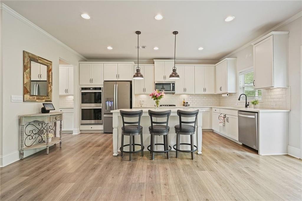 6915 Rambling Vale Dawsonville, GA 30534 - Photo 16 of 63 a kitchen with white cabinets and stainless steel appliances